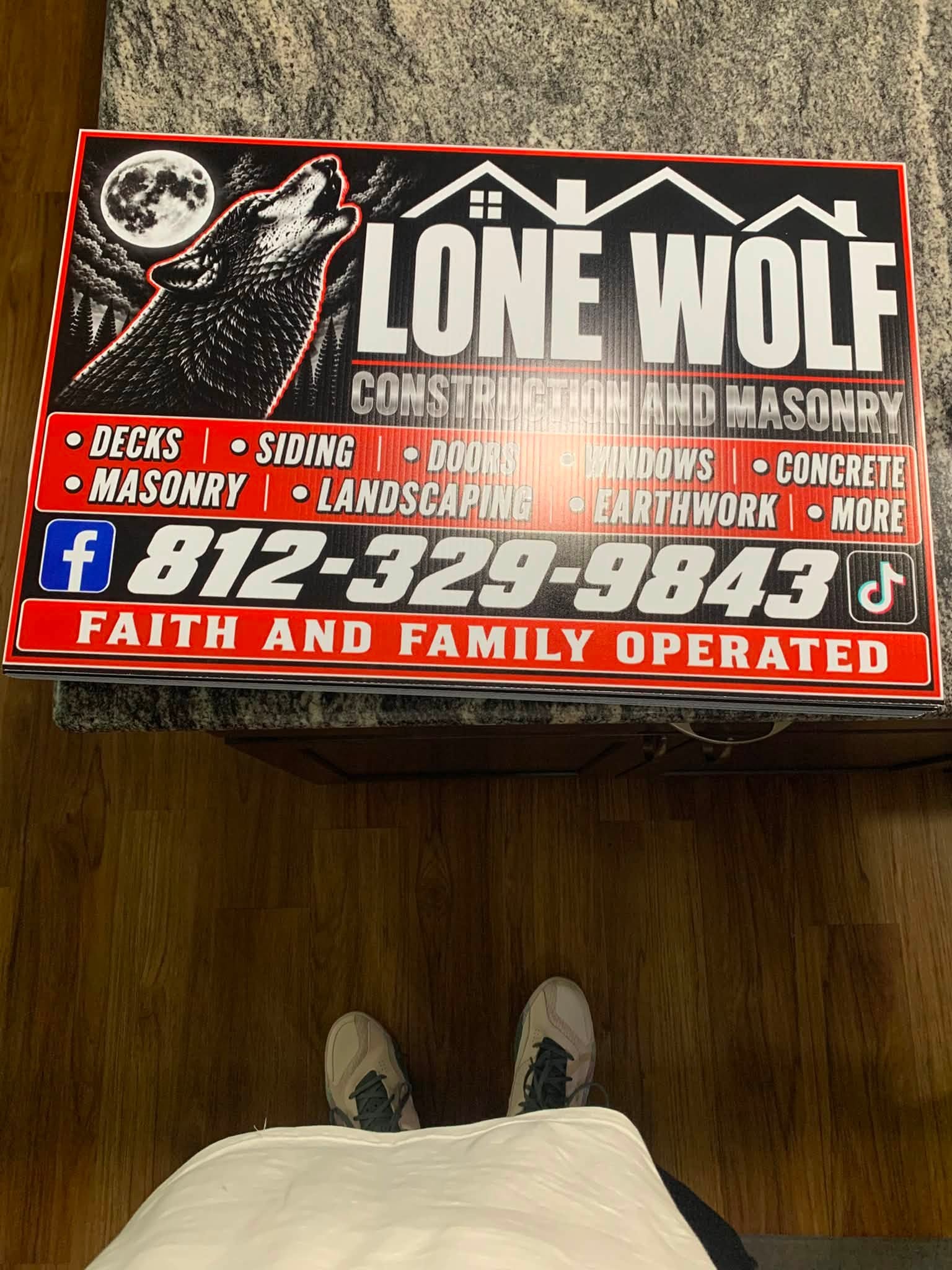 Full-size Lone Wolf Construction and Masonry sign with the howling wolf, service list, and phone number