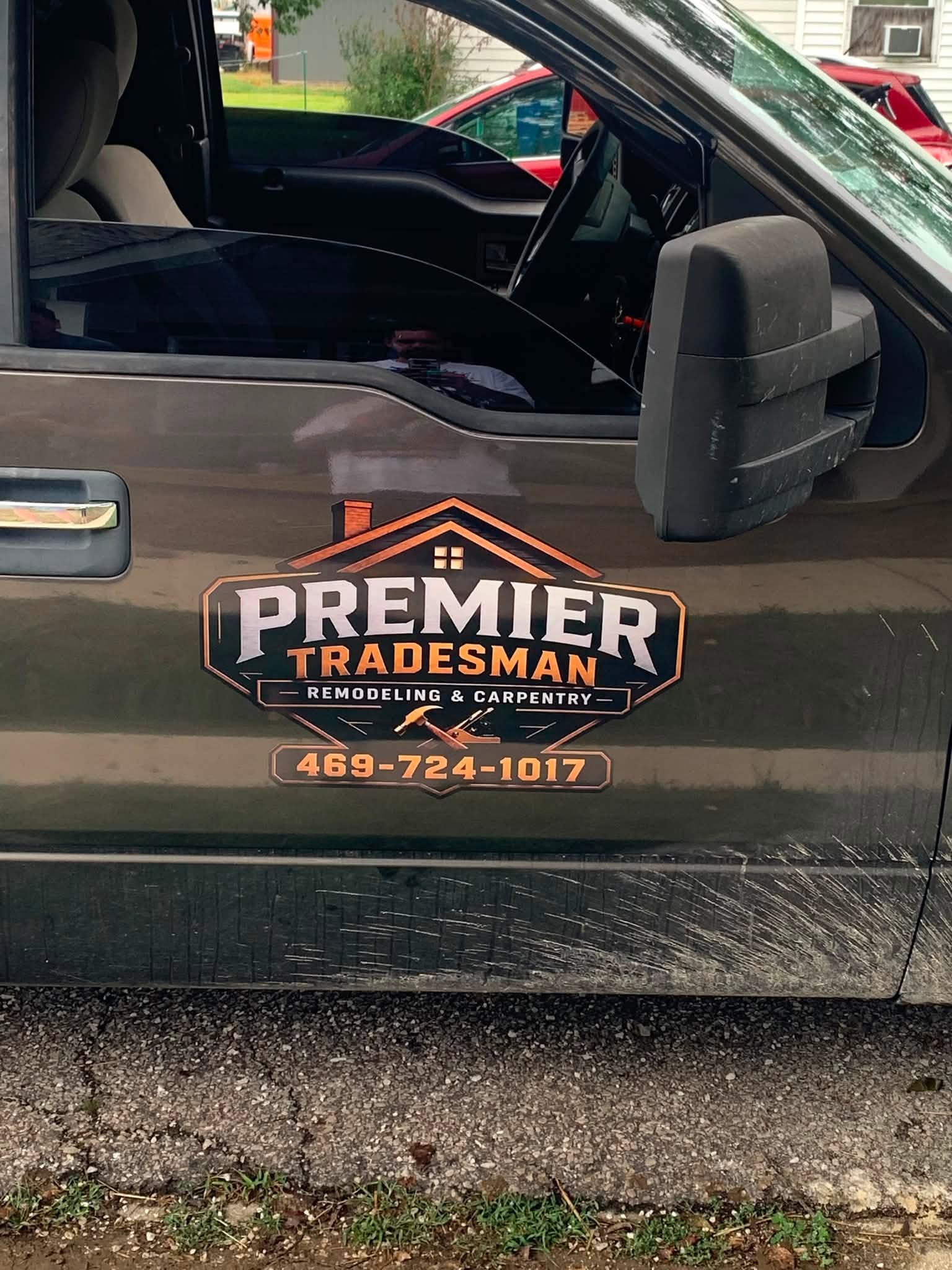 Premier Tradesman Remodeling & Carpentry logo decal applied to the driver's door of a work truck