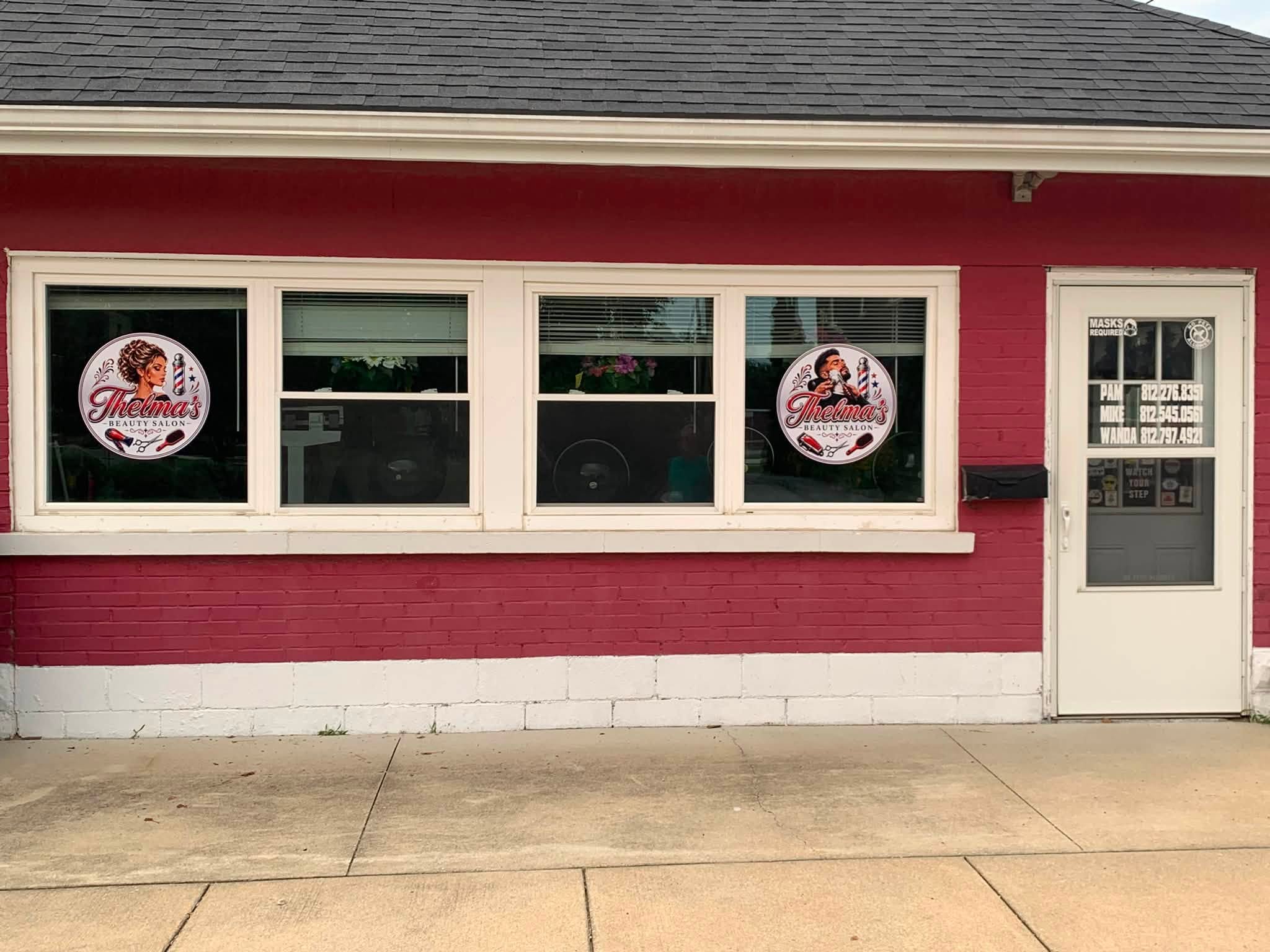 Thelma's Beauty Salon storefront with two circular window decals and lettering on the entry door